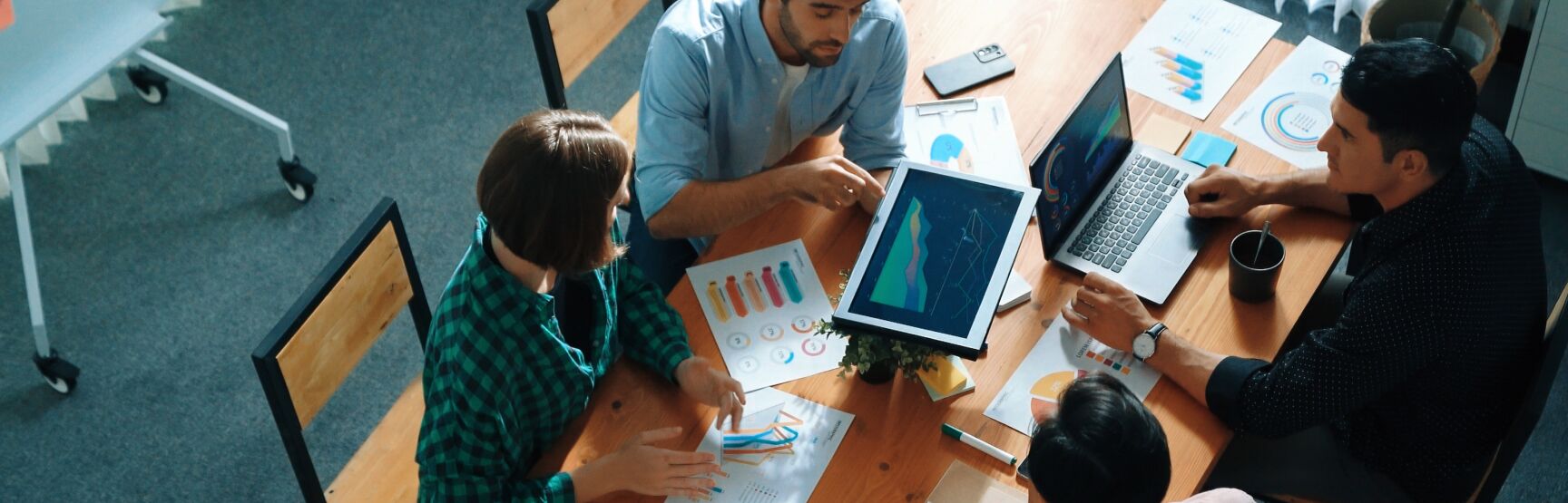 Team reviewing charts and dashboards around a table