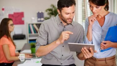 Professional team engaging in a feedback session in a modern office, representing workplace communication and employee development.