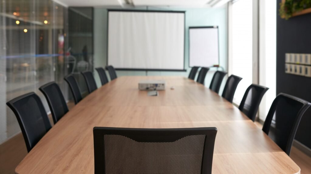 Sedia vuota in una sala riunioni executive, simbolo di una posizione di leadership vacante